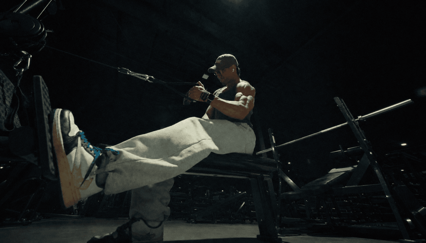 Coaching client performing a seated cable row in a low-lit gym